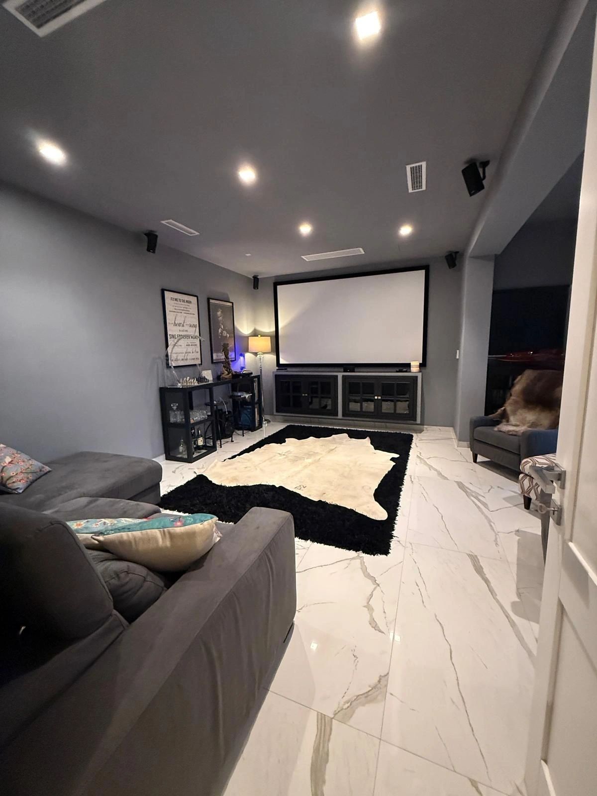 Private cinema room with projection screen and lounge seating